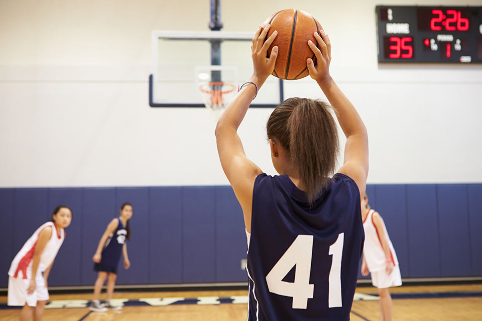 Female high school basketball team playing game